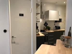 une cuisine avec une porte s'ouvrant sur une cuisine avec une table dans l'établissement Beautiful city apartment at Kallio, à Helsinki