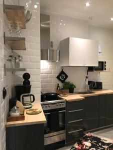Il comprend une cuisine équipée d'une cuisinière et de placards blancs. dans l'établissement Beautiful city apartment at Kallio, à Helsinki