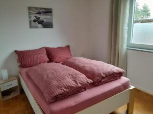łóżko z różową pościelą i oknem w obiekcie Ferienwohnung Im Birkenweg w mieście Mörsdorf