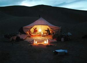 a group of people in a tent in the desert at Desert life in Mhamid