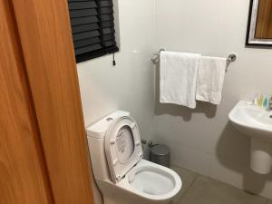 a bathroom with a toilet and a sink and towels at Adis Hotels Prime in Ibadan
