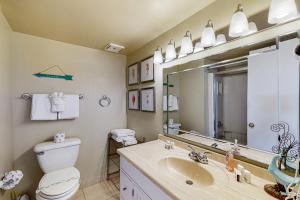 Un baño con inodoro, lavabo y espejo. en Daytona Beach Living - Unit #504, en Daytona Beach 23 fotos más