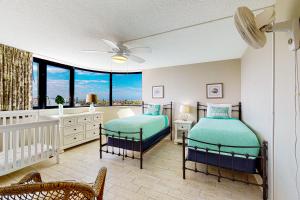 2 camas en una habitación con cuna y ventana en Daytona Beach Living - Unit #504, en Daytona Beach