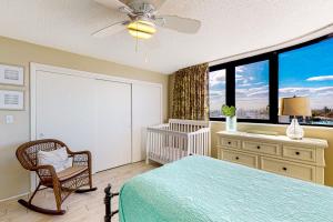 1 dormitorio con cama, cuna y ventanas en Daytona Beach Living - Unit #504, en Daytona Beach