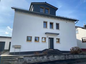 una casa blanca con techo negro en Ferienwohnung Auf der Heide, en Ehringshausen