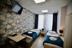 una camera d'albergo con due letti e una tv di Hostel OPEN GARDEN a Częstochowa