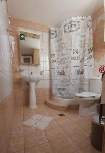 uma casa de banho com uma cortina de chuveiro com escrita em MarGe Apt em Arta