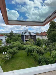 uma vista para um jardim a partir da varanda de uma casa em Eklinds Rum och Trädgård em Gotemburgo