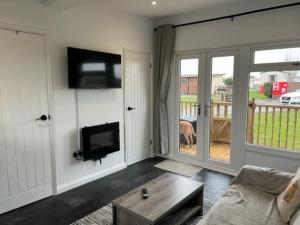 a living room with a dog looking out the door at S and S Chalets Mablethorpe in Mablethorpe