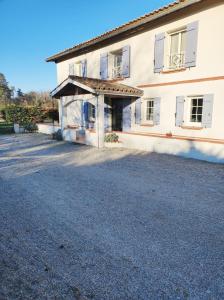 a large white building with a large driveway at Lou Cantou in Nègrepelisse