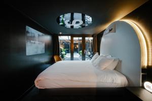 1 dormitorio con cama blanca y ventana en SUPPER Hotel en Ámsterdam