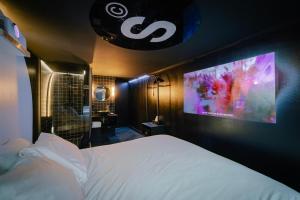 1 dormitorio con 1 cama y TV en la pared en SUPPER Hotel en Ámsterdam