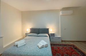 a bedroom with a bed with two towels on it at Extravaganza Room and Suite Apartment City Center in Cagliari