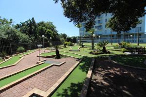 un parc avec des bancs et des arbres et un bâtiment dans l'établissement Santana 107, à Margate