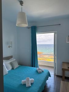 a bedroom with a bed with a view of the ocean at Kimiro Drosia Zante in Psarou