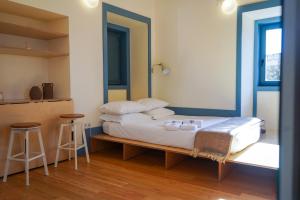 1 dormitorio con 1 cama con 2 taburetes en Cellorico de Sabores, en Celorico da Beira