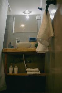 een badkamer met een wastafel, een spiegel en handdoeken bij El Alero Hospedaje in Mendoza