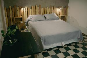 a bedroom with a white bed with a wooden headboard at El Alero Hospedaje in Mendoza