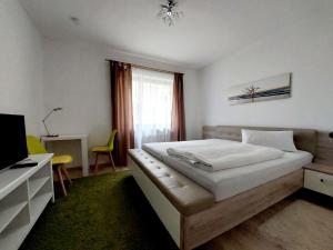 um quarto com uma cama, uma secretária e uma televisão em Pension Hofer em Bad Berneck im Fichtelgebirge