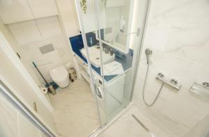 a bathroom with a shower and a sink and a toilet at Orbi City Sea Side & Sea View Apartments in Batumi