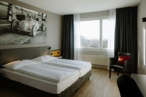 a bedroom with a bed and a large window at Hotel A1 Grauholz in Bern