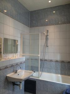 a bathroom with a sink and a shower and a tub at Hôtel De Paris in Charleville-Mézières