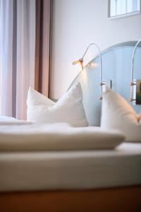 Una cama con dos almohadas y una lámpara. en Ambiente Langenhagen Hannover by Tulip Inn, en Hannover
