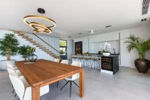a dining room and kitchen with a wooden table and white chairs at Villa Amylia Emerald, design excellence in Koh Samui