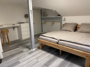 ein Schlafzimmer mit einem Bett und einem Schreibtisch sowie eine Küche in der Unterkunft Ferienwohnung Auf der Heide in Ehringshausen