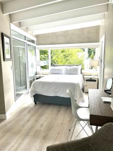 a bedroom with a bed and a large window at One Oak Guest House in Somerset West