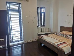 a bedroom with a bed and two windows at Great Black Sea View in Constanţa