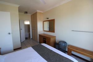 Schlafzimmer mit einem Bett, einem Schreibtisch und einem Spiegel in der Unterkunft Santana 406 in Margate