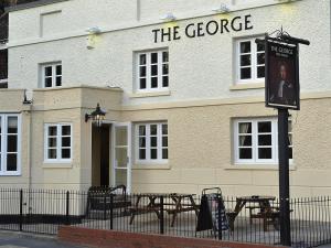 a building with tables and chairs in front of it at The George in Bridgnorth