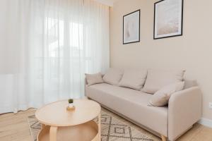 sala de estar con sofá y mesa en Beaufort Estate Apartment by Renters, en Gdynia