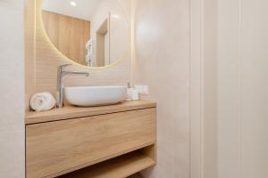 uma casa de banho com um lavatório e um espelho em Beaufort Estate Apartment by Renters em Gdynia