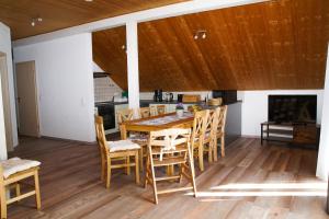 een eetkamer met een houten tafel en stoelen bij Ferienwohnung Andermann in Neukirchen