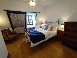 1 dormitorio con 1 cama, 1 silla y 1 ventana en Château de Chauvac - Chambres et table d'hôtes avec vue sur la rivière en Bassignac-le-Bas