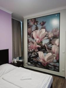 a bedroom with a large painting of flowers on the wall at Albert rooms in Berlin