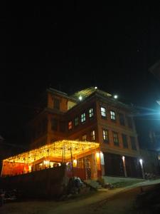 a large brick building with lights on it at night at The Nest Guest House in Changunarayan