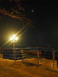 a bench sitting next to a light pole at night at The Nest Guest House in Changunarayan