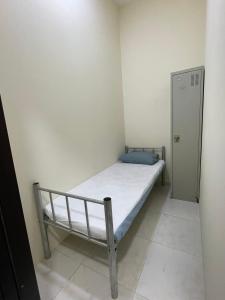 una piccola camera con un letto in una stanza di WAA Hostel a Dubai