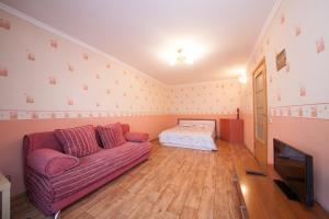 a living room with a couch and a bed at Kvartirov Apartment at Surikova in Krasnoyarsk