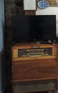 una TV a schermo piatto seduta su un supporto in legno di Casas do Durão-Memories House a Lajeosa