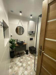 baño con lavabo, espejo y puerta en Stodoła na polanie en Poronin