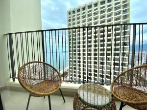 ニャチャンにあるGold Coast Luxury Apartment Nha Trangの建物の景色を望むバルコニー(椅子3脚付)