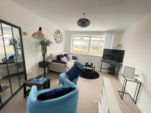 a living room with blue chairs and a couch at Cambridge Stay Cozy home with Wi-Fi, Parking Perfect for 2 in Cherry Hinton