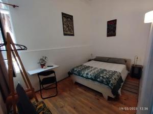 a bedroom with a bed and a table in it at Escarabajo Hostel in Valparaíso