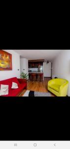 sala de estar con sofá rojo y silla amarilla en Departamento Concepción II, en Concepción