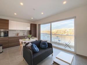 a living room with a couch and a large window at Seafront 1st floor Apartment in Marsaskala by Solea in Marsaskala