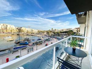 a balcony with a view of a harbor with boats at Seafront 1st floor Apartment in Marsaskala by Solea in Marsaskala